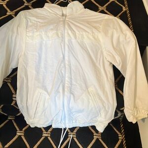 Beautiful white windbreaker with a hood that tucks in. Zip up.